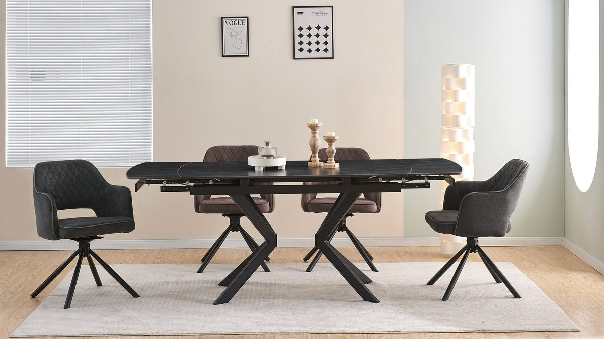 Extending black sintered stone dining table fully expanded with modern swivel chairs in a furnished dining room, T-105 