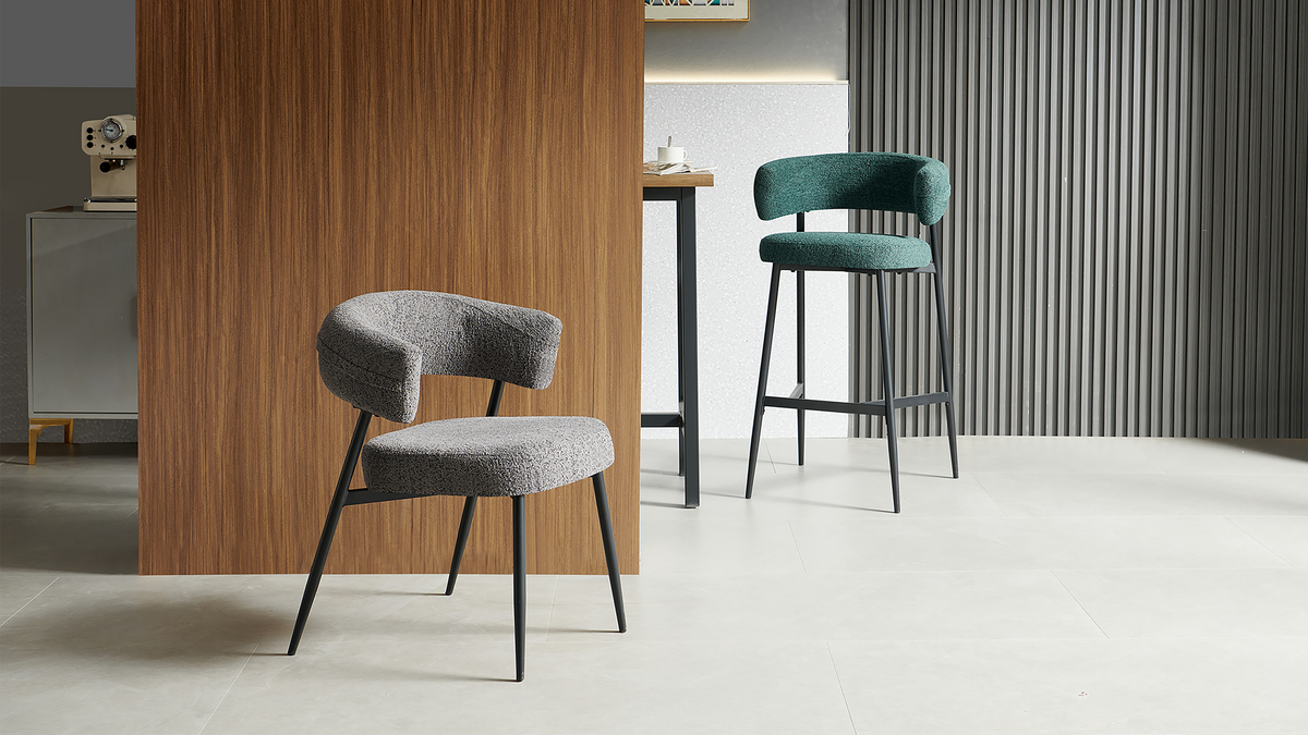 Bouclé bar stool in deep teal beside a raised counter and dark vertical wall slats, with a separate low chair in the foreground, BC-89-750
