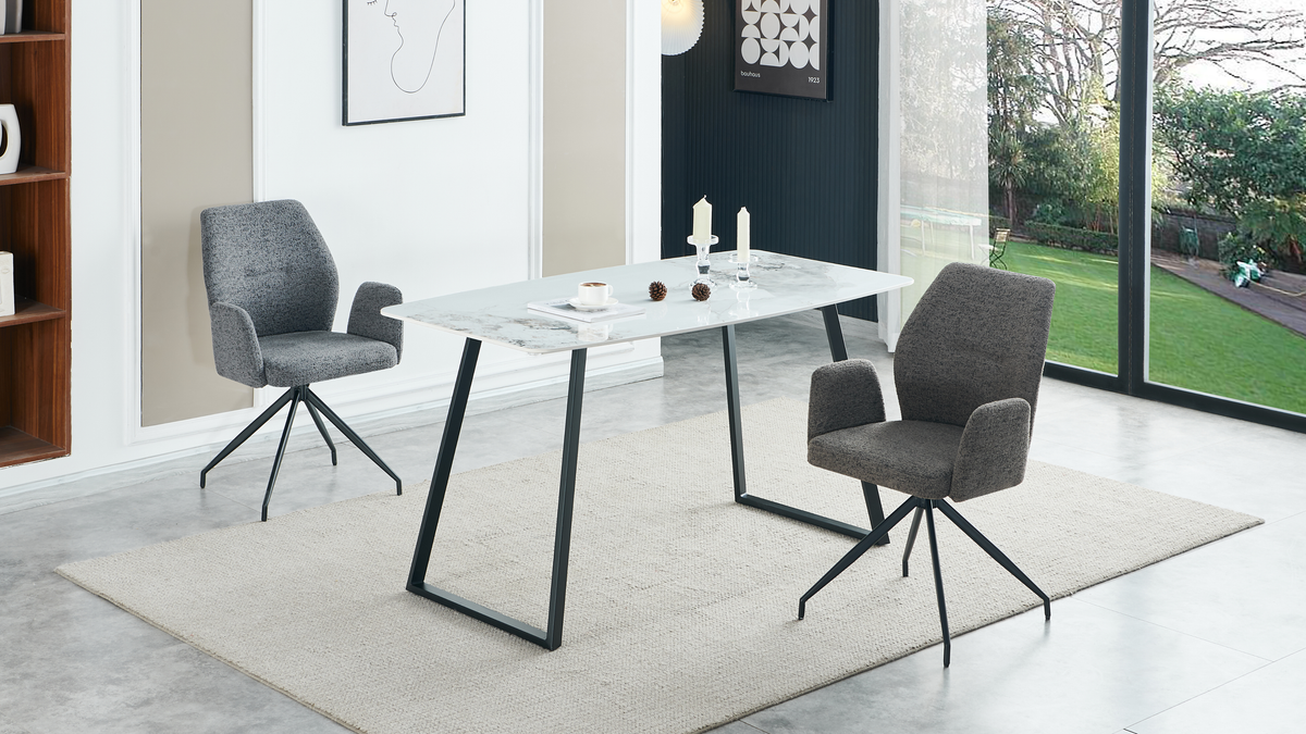 Bow-sided sintered stone dining table with grey armchairs in a sunlit dining space overlooking a garden patio, T-122