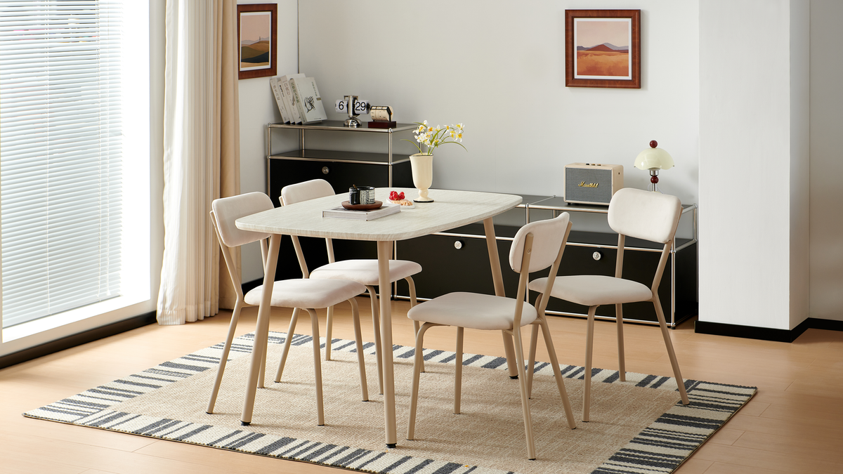 Bow-top stone-effect dining table with black steel legs and woven chairs in a sunlit glasshouse, T-189