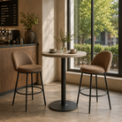 Chenille curved-shell counter stools in camel brown around round bistro table in boutique café with floor-to-ceiling windows, BC-165