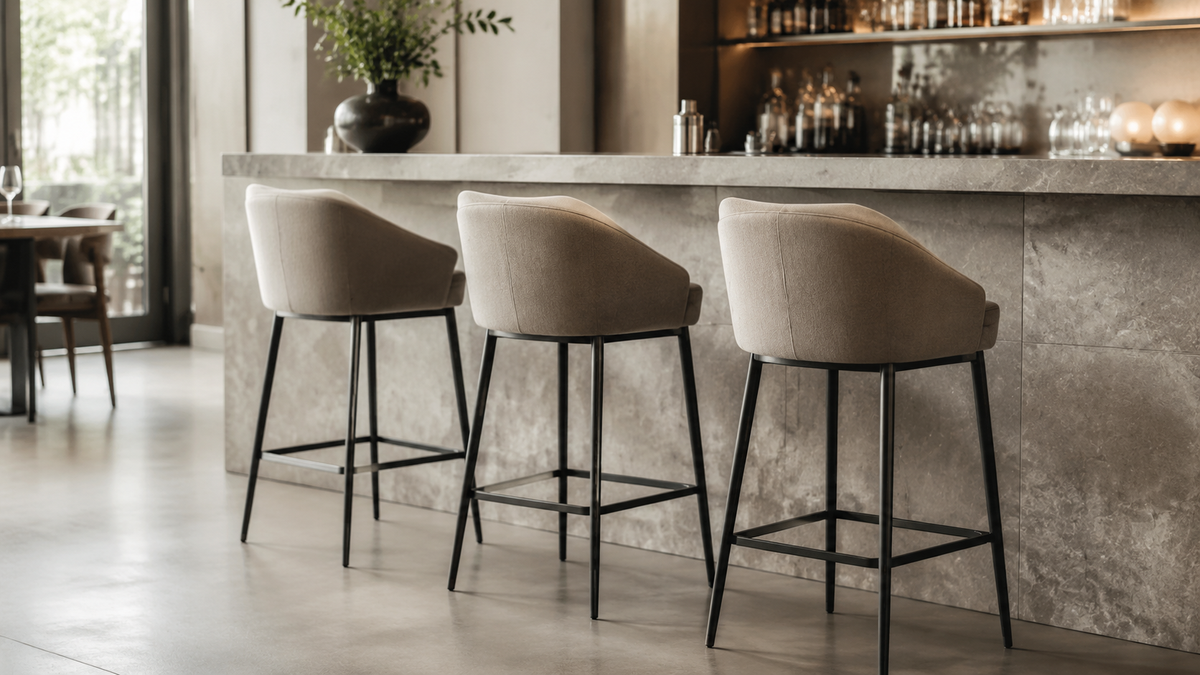 Upholstered 30-inch commercial bar stools with slim metal frames positioned at a standard bar-height counter.