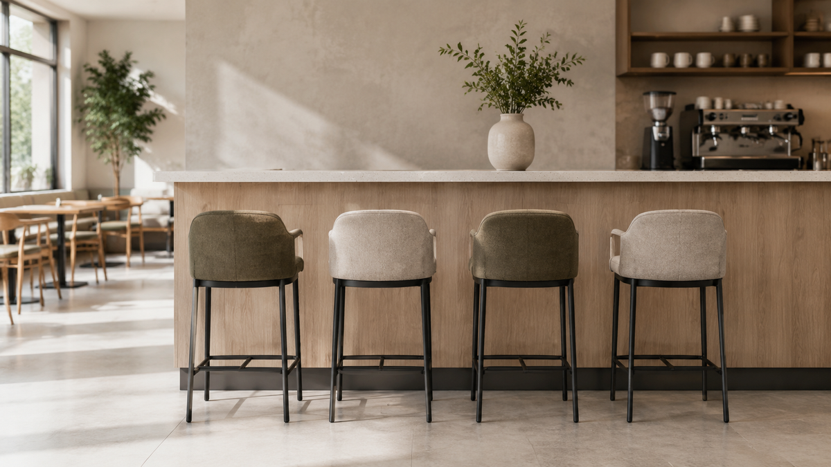 Upholstered counter stools with metal frames at a contemporary café counter.
