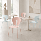 Cut-out back polypropylene side chairs in blush pink and pale mint arranged in a gallery café with sculptural décor and floor-to-ceiling windows, PC-96