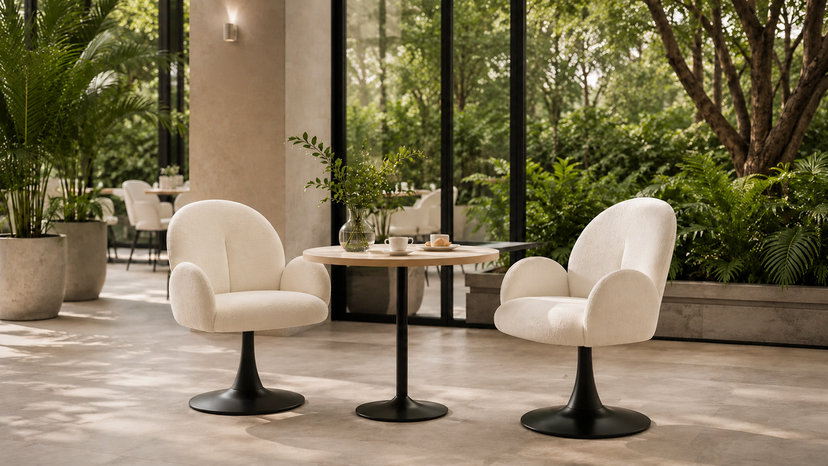 Upholstered swivel lounge chairs with matte black pedestal bases on a garden-view hotel lounge terrace