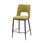 Decorative bouclé open-back counter stool in olive yellow with tapered black steel frame and integrated footrest — GEYA Seating BC-120