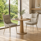 High-back upholstered dining chairs in warm greige woven fabric for a window-side residential dining nook with slim metal legs and a small round oak table.