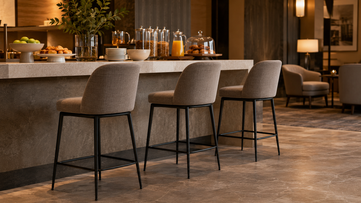 Upholstered counter-height stools with metal frames at an indoor restaurant service counter.