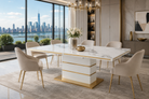 T-200 extendable marble-effect dining table with gold trim in a luxury penthouse dining room overlooking a city skyline.