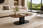 CT-38 walnut-effect rounded coffee table in a modern residential living room with a cream sofa, light textured rug and clear garden view.