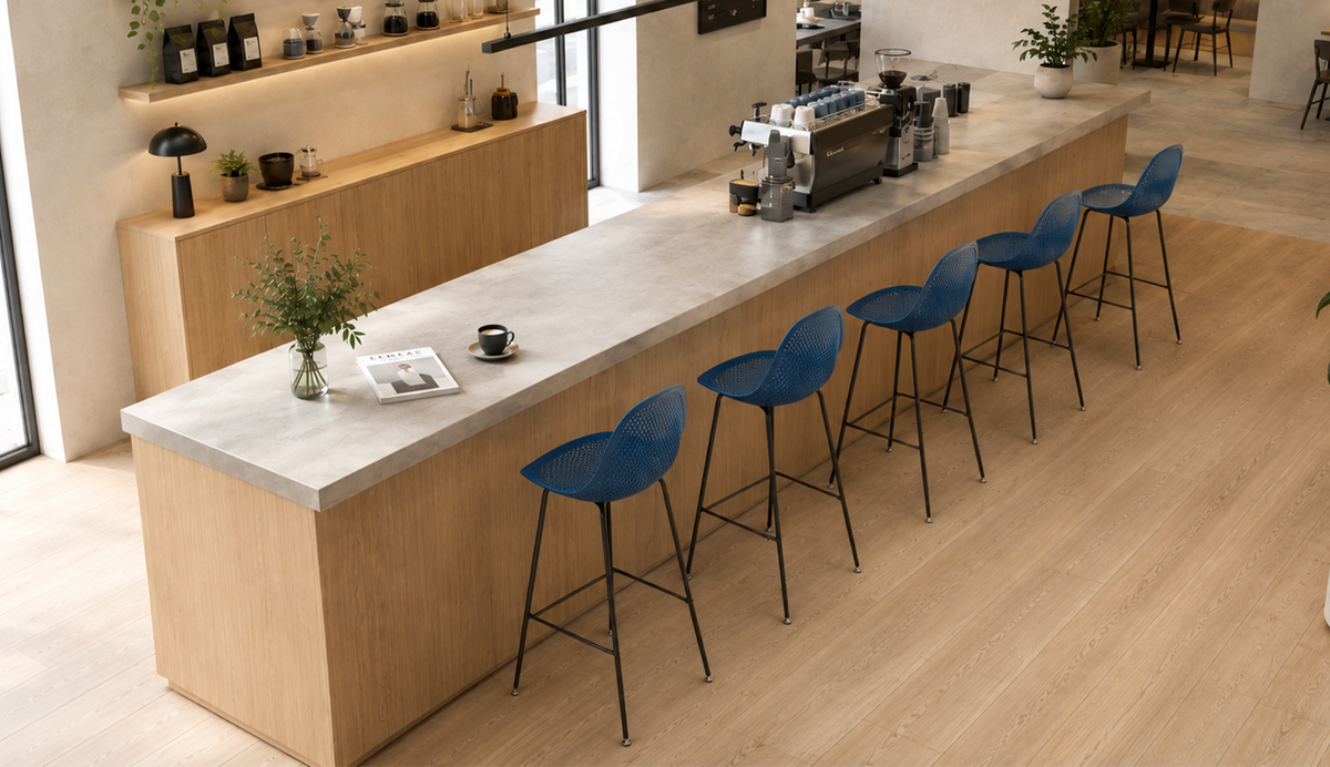 Perforated polypropylene bar stools in deep blue along a specialty coffee bar counter with concrete worktop, café interior, PC-76