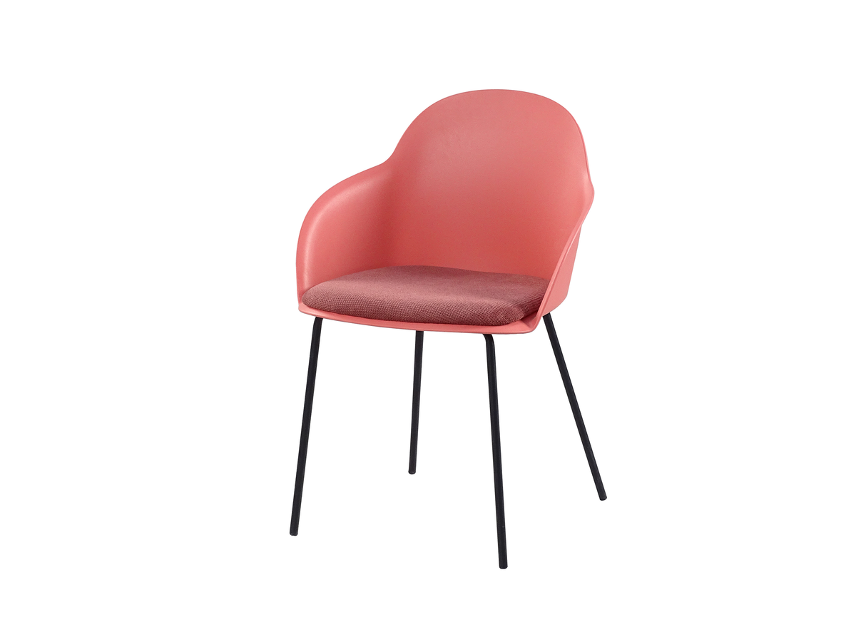 Three-quarter view of coral shell-back polypropylene dining armchair with woven seat pad and black steel legs PC-16