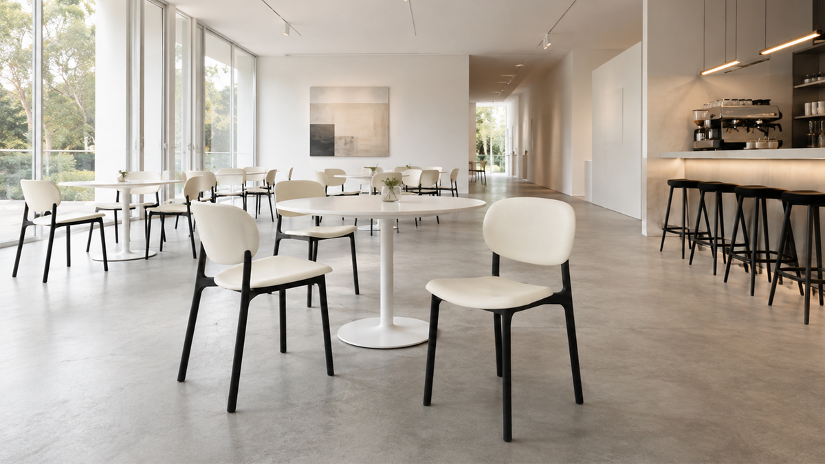 PP side chairs in Ivory on black frames arranged across a gallery café with round tables PC-103 