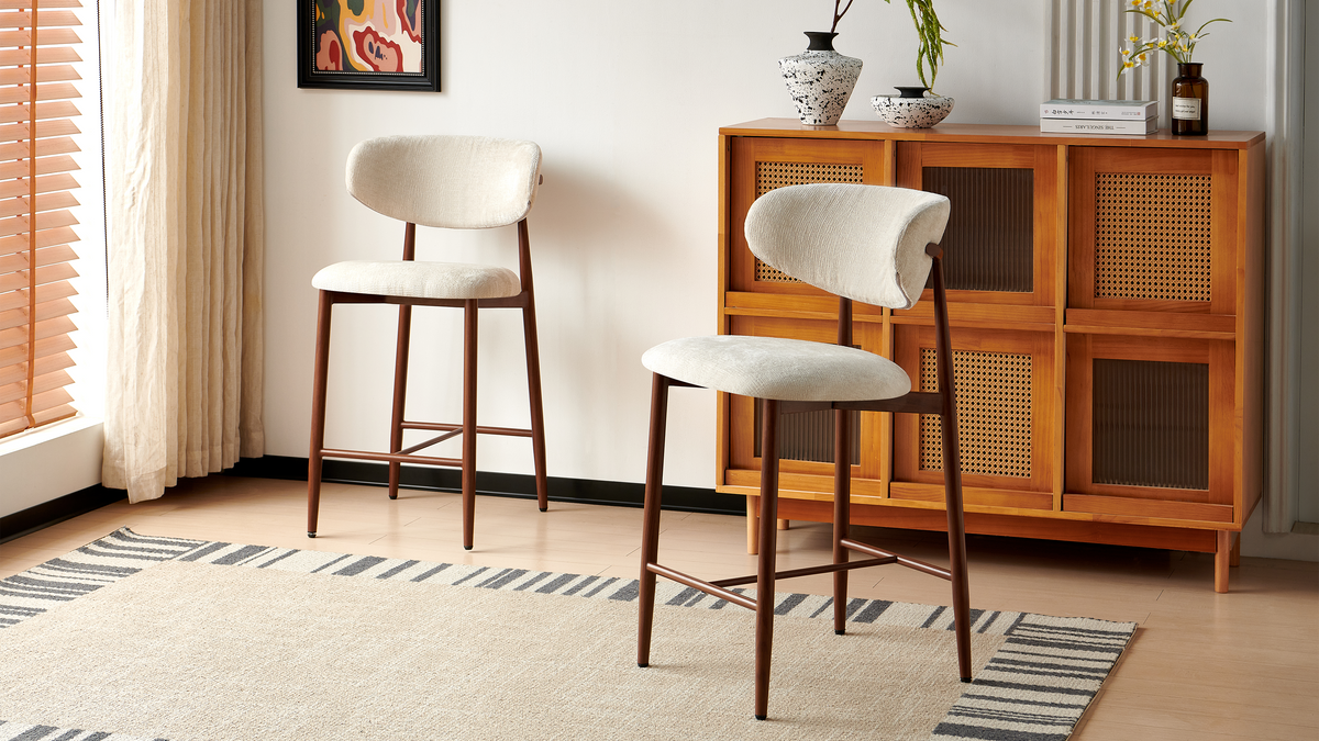 Upholstered bar stools in ivory white beside wood-look cabinetry, showing separate seats and backrests, BC-157-750

